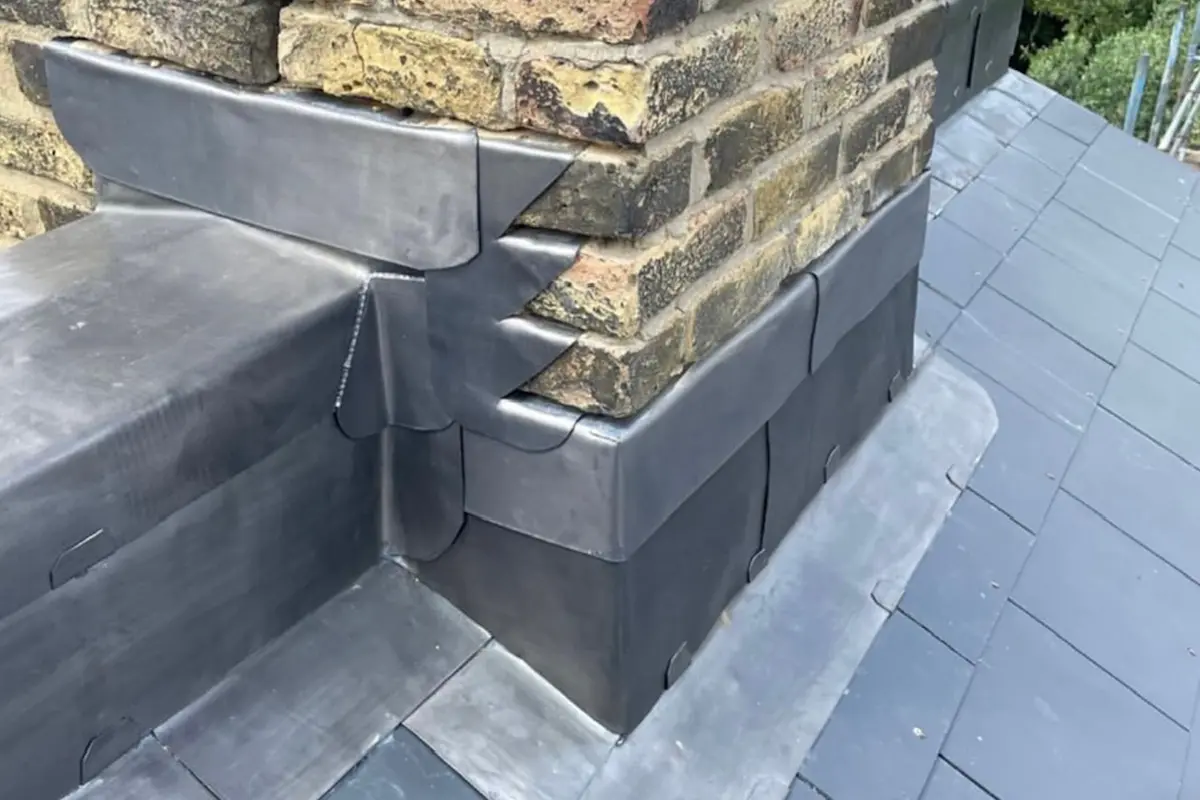 Hand-dressed scalloped Code 5 lead step flashing on Victorian brick chimney